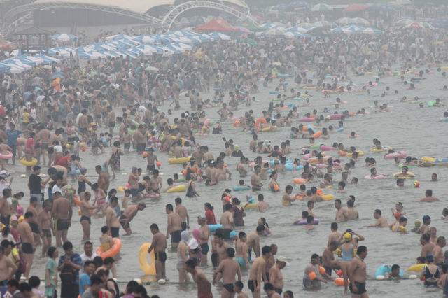 山东青岛持续高温 海滨浴场游客扎堆如“下饺子”